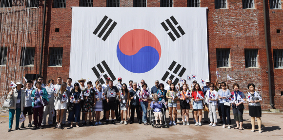 광복절을 하루 앞둔 14일 오전 서울 서대문형무소역사관을 찾은 국외 거주 독립유공자 후손들이 독립군의 노래를 들으며 태극기를 흔들고 있다. 2019.8.14 오장환 기자 5zzang@seoul.co.kr