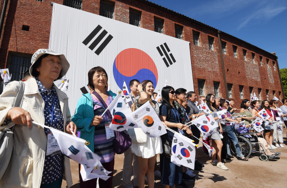 광복절을 하루 앞둔 14일 오전 서울 서대문형무소역사관을 찾은 국외 거주 독립유공자 후손들이 독립군의 노래를 들으며 태극기를 흔들고 있다. 2019.8.14 오장환 기자 5zzang@seoul.co.kr