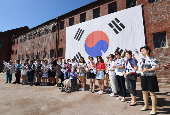 광복절을 하루 앞둔 14일 오전 서울 서대문형무소역사관을 찾은 국외 거주 독립유공자 후손들이 독립군의 노래를 들으며 태극기를 흔들고 있다. 2019.8.14 오장환 기자 5zzang@seoul.co.kr