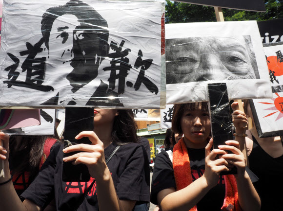 14일 대만의 타이베이에서 열린 위안부 기림일 연대집회에서 참가자들이 아베 신조 일본 총리의 얼굴이 새겨진 피켓 등을 들고 일본 정부의 사과를 촉구하고 있다. 타이베이 EPA 연합뉴스