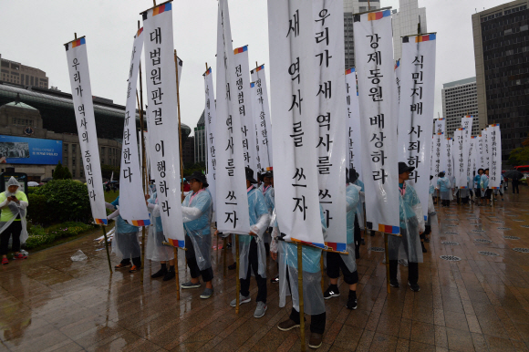 15일 서울 시청광장에서 열린 강제동원 공동행동주최 국제평화집회에 참석한 시민들이 깃발을 들고 행진을 하고 있다.  2019.8.15  박지환기자 popocar@seoul.co.kr