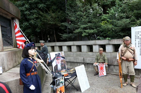 한국의 광복절이자 일본의 패전일인 15일 일본 도쿄(東京) 지요다(千代田)구의 야스쿠니신사(靖國神社)에서 제국주의 일본군의 군복을 입은 사람들이 욱일기를 들고 있다. 2019.8.15  연합뉴스