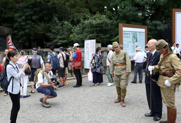한국의 광복절이자 일본의 패전일인 15일 일본 도쿄(東京) 지요다(千代田)구의 야스쿠니신사(靖國神社)에서 참배자들이 제국주의 일본군의 군복을 입은 사람들과 기념 촬영을 하고 있다. 2019.8.15  연합뉴스