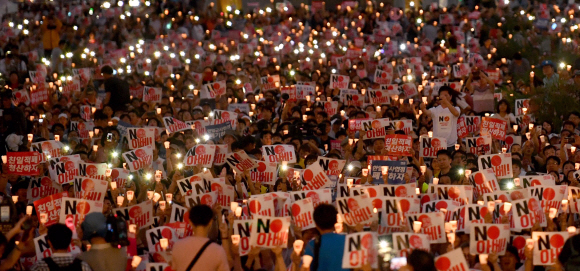 15일 저녁 서울 광화문광장에서 열린 ‘8·15 제74주년 아베 규탄 및 정의 평화 실현을 위한 범국민 촛불 문화제’에 참석한 시민들이 촛불과 ‘NO 아베’ 피켓을 양손에 들고 일본 아베 정부를 규탄하고 있다. 이날 문화제에는 10만명(주최 측 추산)이 참석했다. 박지환 기자 popocar@seoul.co.kr