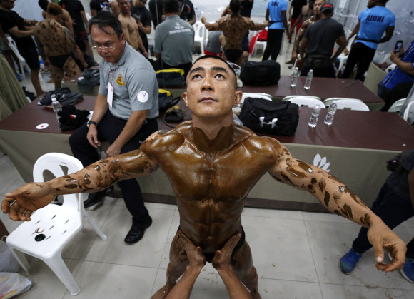 보디 빌더들이 17일(현지시간) 태국 방콕에서 열린 ‘아시아 태평양 보디 빌딩 챔피언십 2019’무대 뒤에서 멋진 근육을 선보이며 준비하고 있다. 이 대회에서는 아시아 태평양 국가들의 수백 명의 보디빌더들이 서로 멋진 근육을 과시하며 경쟁한다. EPA 연합뉴스