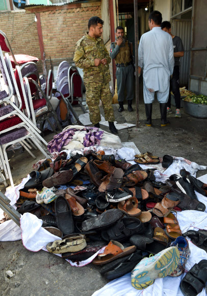 18일(현지시간) 아프가니스탄 카불에서 결혼식 피로연을 목표로 한 자살 폭탄 폭발후 파손된 두바이 시티 결혼식장에 남겨진 신발들이 있다. 붐비는 토요일 밤, 자살 폭탄 테러가 결혼식 파티를 뚫고 들어왔다. AFP 연합뉴스 