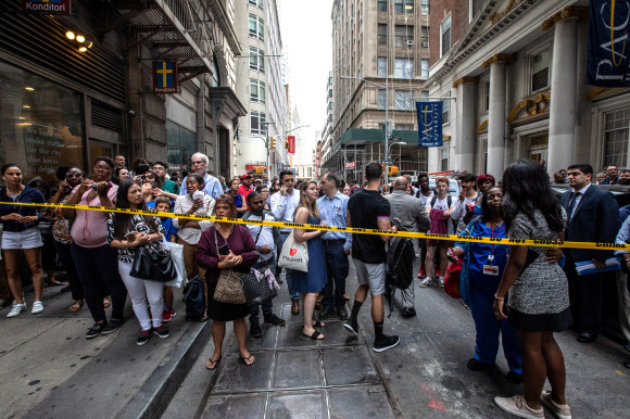 미국 뉴욕 맨해튼의 풀턴 지하철역에서 지난 16일(현지시간) 폭발물로 의심되는 전기밥솥 2개가 발견돼 경찰이 지하철역 접근을 통제하자 시민들이 통제선 주변에서 상황을 살피고 있다.  뉴욕 로이터 연합뉴스