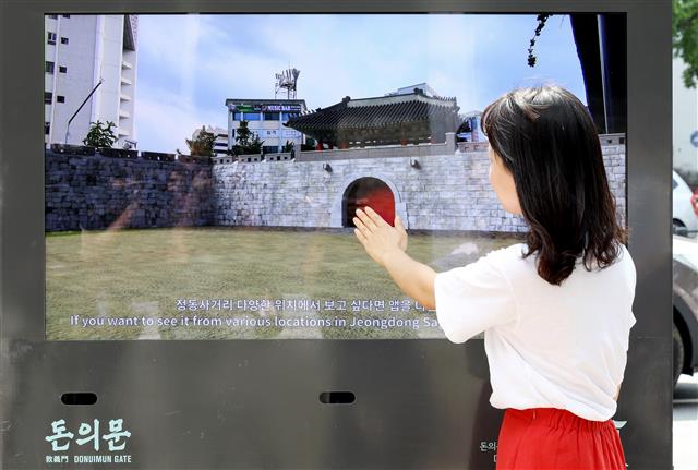 한 시민이 20일 서울 종로구 돈의문박물관마을에서 열린 ‘돈의문 IT(정보기술) 건축 개문식’에서 증강현실(AR)·가상현실(VR) 기술을 통해 복원된 돈의문을 살펴보고 있다. 뉴스1