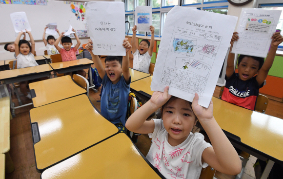 21일 오전 여름방학을 마치고 개학한 서울 용산구 용산초등학교에서 학생들이 방학 숙제를 보여주고 있다. 2019.8.21 오장환 기자 5zzang@seoul.co.kr