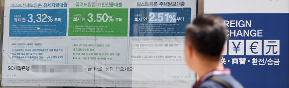 지난 6월 말 기준 우리나라 가계빚이 1550조원을 넘어선 가운데 한 시민이 22일 서울시내 은행 지점 밖에 걸린 대출금리 안내 현수막을 바라보고 있다. 오장환 기자 5zzang@seoul.co.kr