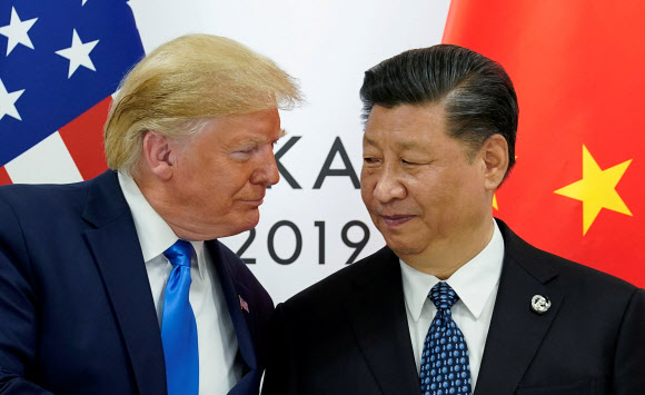 도널드 트럼프(왼쪽) 미국 대통령과 시진핑 중국 국가주석이 지난 6월 일본 오사카에서 열린 미중 정상회담에 묘한 미소를 띤 채 마주보고 있다. 연합뉴스
