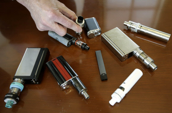 지난해 일리노이주 한 고등학교에서 교장이 학생들에게서 압수한 각종 전자담배 기기를 책상 위에 펼쳐 놓은 모습을 찍은 자료사진 AP 연합뉴스