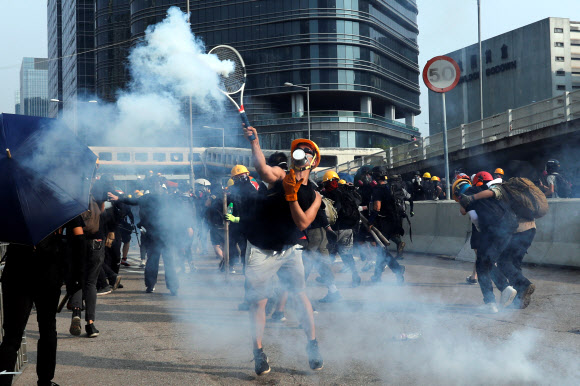 홍콩 ‘범죄인인도법안’ 반대 시위가 또 열린 지난 24일 카오룽 지역에서 한 시민이 경찰이 쏜 최루탄을 테니스 라켓으로 쳐내고 있다. 홍콩 로이터 연합뉴스