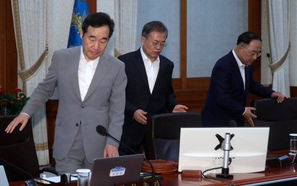 문재인 대통령이 29일 청와대에서 열린 국무회의에서 국민의례를 한 뒤 자리에 앉고 있다. 왼쪽은 이낙연 국무총리. 2019. 08.29. 도준석 기자pado@seoul.co.kr