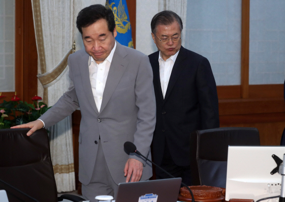 문재인 대통령이 29일 청와대에서 열린 국무회의에서 국민의례를 한 뒤 자리에 앉고 있다. 왼쪽은 이낙연 국무총리. 2019. 08.29. 도준석 기자pado@seoul.co.kr