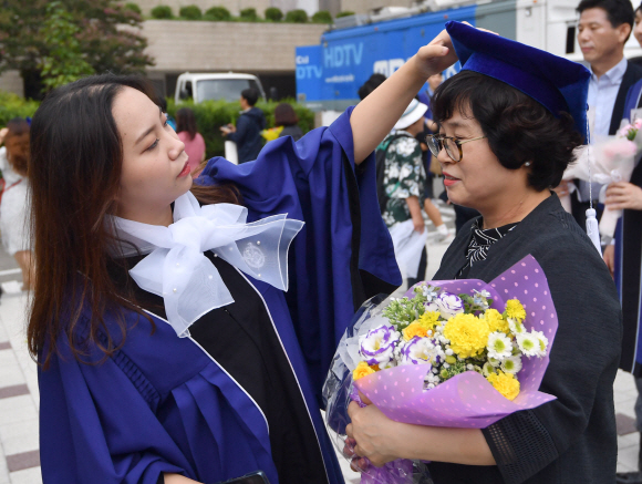 29일 서울 관악구 서울대학교에서 열린 졸업식에서 학생이 부모에게 학사모를 씌워주고 있다. 2019.8.29 박지환기자 popocar@seoul.co.kr