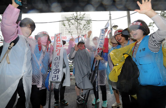 한국도로공사가 고속도로 요금소 수납원들을 직접 고용해야 한다는 취지의 대법원 판결이 내려진 29일 서울 서초구 대법원 앞에서 대기 중이던 톨게이트노조 조합원들이 판결 소식을 듣고 환호하고 있다. 연합뉴스