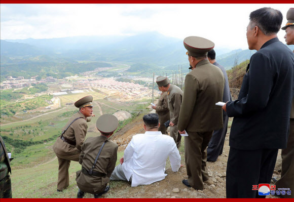 김정은 북한 국무위원장이 개장을 앞둔 평안남도 양덕군 온천관광지구 건설장을 현지 지도했다고 조선중앙통신이 31일 보도했다. 사진은 중앙통신이 홈페이지에 공개한 것으로, 흙바닥에 주저앉아 보고를 받는 김정은 국무위원장의 모습. 2019.8.31  연합뉴스