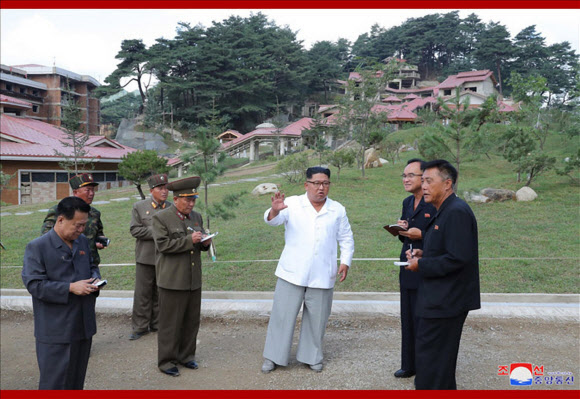 김정은 북한 국무위원장이 개장을 앞둔 평안남도 양덕군 온천관광지구 건설장을 현지 지도했다고 조선중앙통신이 31일 보도했다. 사진은 중앙통신이 홈페이지에 공개한 것으로, 수행 간부들을 상대로 발언하는 김 위원장의 뒷편으로 휴양지 리조트풍의 건물들이 눈에 띈다. 2019.8.31  연합뉴스