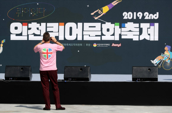 31일 오전 인천시 부평구 부평동 부평역 앞 쉼터광장에서 열린 ‘2019 제2회 인천퀴어문화축제’에서 한 참가자가 축제 홍보물을 촬영하고 있다. 2019.8.31  연합뉴스