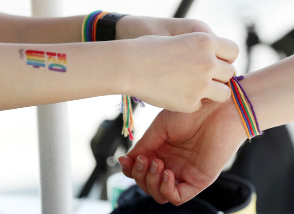 31일 오전 인천시 부평구 부평동 부평역 앞 쉼터광장에서 열린 ‘2019 제2회 인천퀴어문화축제’에서 한 축제 참가자가 다른 참가자 손목에 무지개 색깔 팔찌를 채워주고 있다. 2019.8.31  연합뉴스
