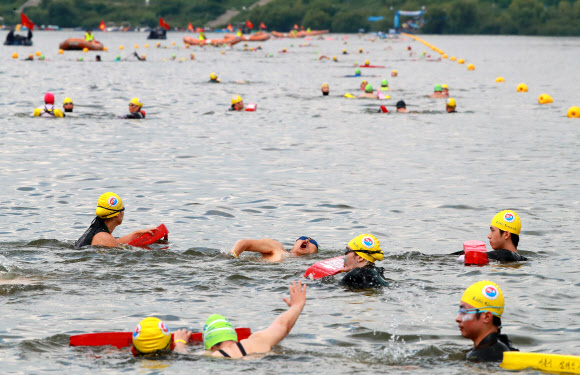 31일 서울 송파구 잠실한강공원에서 열린 ‘제13회 장애인수영 한강건너기 대회’에서 장애인 참가자와 안전요원들이 1.6km 떨어진 뚝섬한강공원까지 수영으로 한강을 건너고 있다. 2019.8.31  연합뉴스
