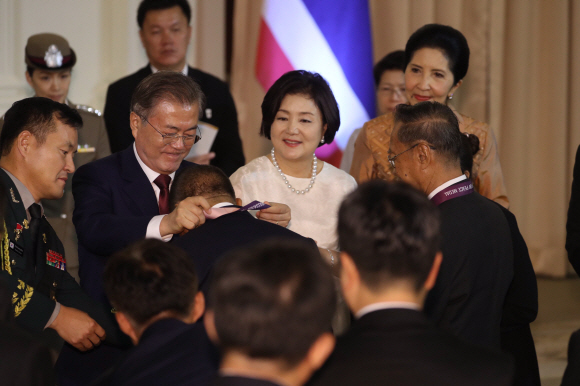 문재인 대통령과 김정숙 여사가 2일 방콕 총리실 청사에서 한국전 참전 용사인 전 태국 육군 대령 아폰부다카나카에게 ‘평화의 사도 메달’을 전달하고 있다. 쁘라윳 짠오차 총리의 제안으로 이뤄진 이번 만남에는 한국전 당시 폭찹고지 전투 중대장으로 활약한 아폰 우타까녹 등 6명의 한국전 참전용사와 반딧 마라이아리순 태국 한국전참전협회 회장, 참전용사의 후손 및 한국전 실종자 가족 등이 참석했다. 평화의 사도 메달은 한국전쟁에서의 희생과 공헌을 기억하고, 감사와 예우를 표명하기 위해 1975년부터 유엔참전용사에게 수여하고 있다. 2019. 09.02. 도준석 기자pado@seoul.co.kr