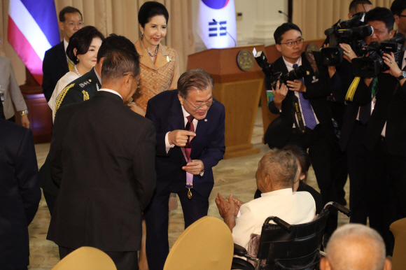 문재인 대통령과 김정숙 여사가 2일 방콕 총리실 청사에서 한국전 참전 용사인 전 태국 육군 대령 아폰부다카나카에게 ‘평화의 사도 메달’을 전달하고 있다. 쁘라윳 짠오차 총리의 제안으로 이뤄진 이번 만남에는 한국전 당시 폭찹고지 전투 중대장으로 활약한 아폰 우타까녹 등 6명의 한국전 참전용사와 반딧 마라이아리순 태국 한국전참전협회 회장, 참전용사의 후손 및 한국전 실종자 가족 등이 참석했다. 평화의 사도 메달은 한국전쟁에서의 희생과 공헌을 기억하고, 감사와 예우를 표명하기 위해 1975년부터 유엔참전용사에게 수여하고 있다. 2019. 09.02. 도준석 기자pado@seoul.co.kr