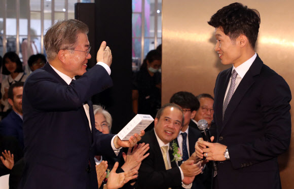 문재인 대통령이 2일 오후(현지시간) 방콕 센트럴월드 쇼핑몰에서 열린 ‘브랜드K 론칭쇼’에서 박지성 브랜드K 홍보대사가 전달한 아이마스크를 받은 후 손으로 쓰는 시늉을 하고 있다. 2019.9.2  연합뉴스