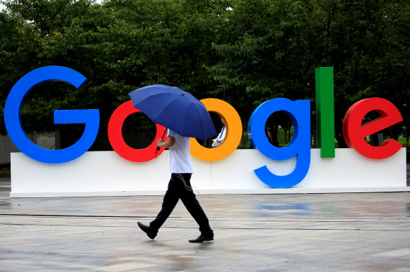 미국 50개 주 가운데 절반이 넘는 주 사법당국이 구글에 대해 반독점 위반 혐의로 조사할 예정이다. 사진은 지난 2018년  8월 27일 중국 상하이에서 우산을 쓴 한 시민이 ‘구글 광고’판 앞을 지나고 있다. 상하이 이 로이터 연합뉴스  