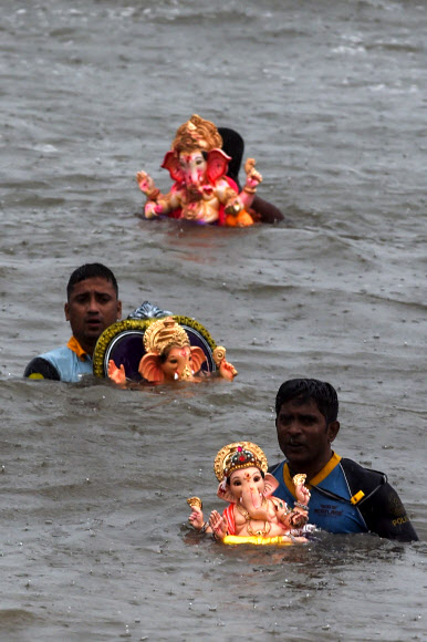 인도 힌두교 신자들이 7일(현지시간) 인도 뭄바이의 가네쉬 차투르티 축제 기간 동안 코끼리 머리의 힌두교 신 가네샤 경의 우상을 아라비아로 옮기고 있다. AFP 연합뉴스