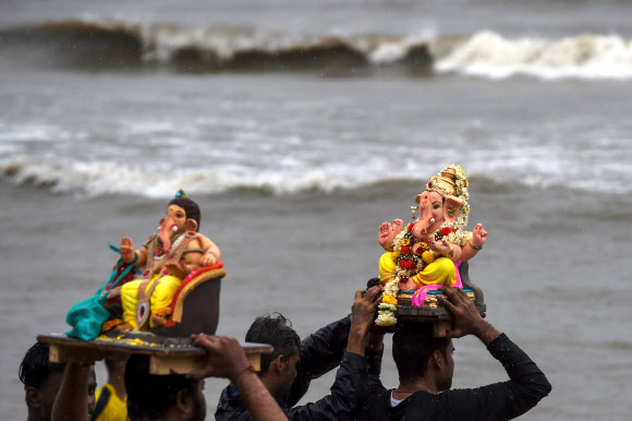 인도 힌두교 신자들이 7일(현지시간) 인도 뭄바이의 가네쉬 차투르티 축제 기간 동안 코끼리 머리의 힌두교 신 가네샤 경의 우상을 아라비아로 옮기고 있다. AFP 연합뉴스