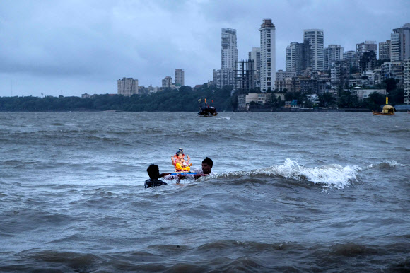 인도 힌두교 신자들이 7일(현지시간) 인도 뭄바이의 가네쉬 차투르티 축제 기간 동안 코끼리 머리의 힌두교 신 가네샤 경의 우상을 아라비아로 옮기고 있다. AFP 연합뉴스