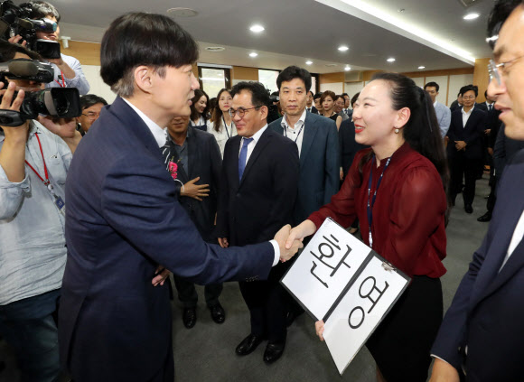 조국, ‘환영’ 팻말 든 직원과 악수