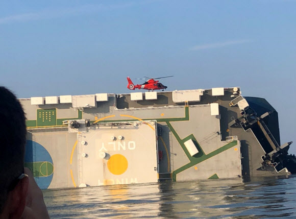 미국 해안경비대 헬리콥터가 9일(현지시간) 오전 미국 조지아주 브런즈윅항 인근 바다에서 전도된 현대글로비스 소속 자동차 운반선 골든레이호 위에 구조 작업을 위해 착륙하고 있다. 골든레이호 안에는 한국인 선원 4명이 고립된 것으로 알려졌다. <br>미국 해안경비대 트위터 캡처