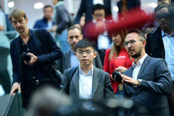 홍콩 ‘우산혁명’의 주역이자 ‘범죄인인도법안’ 반대 시위를 이끌고 있는 민주화 운동가 조슈아 웡(앞줄 왼쪽)이 11일 독일 베를린에서 기자회견을 마친 뒤 걸어 나오고 있다.  베를린 EPA 연합뉴스