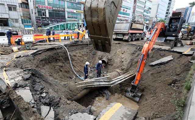 14일 오전 경기 안양시 동안구 인덕원역 사거리 광역 상수관 파열 현장에서 관계자들이 긴급 복구 작업을 벌이고 있다.  전날 밤 발생한 이 사고로 이지역 일대 지반이 일부 내려앉아 차량 10여대가 침수되고 현재 인덕원역 앞 편도 7차로 도로 300여m 구간 일부가 통제되고 있다. 2019.9.14 뉴스1
