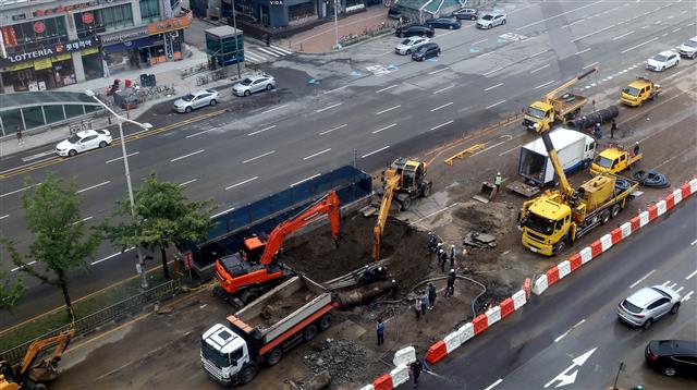 14일 오전 경기 안양시 동안구 인덕원역 사거리 광역 상수관 파열 현장에서 관계자들이 긴급 복구 작업을 벌이고 있다.  전날 밤 발생한 이 사고로 이지역 일대 지반이 일부 내려앉아 차량 10여대가 침수되고 현재 인덕원역 앞 편도 7차로 도로 300여m 구간 일부가 통제되고 있다. 2019.9.14 뉴스1