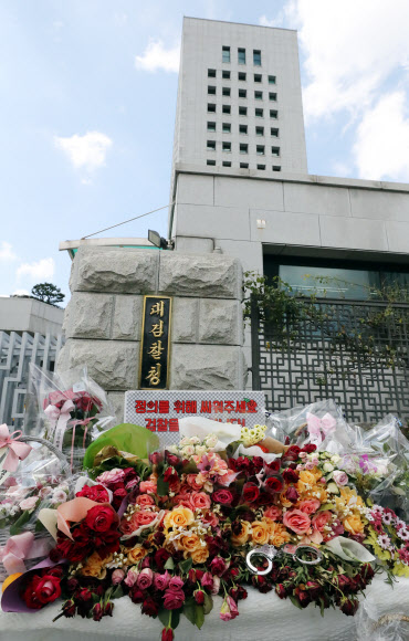 이번엔 檢응원하는 꽃과 수갑  15일 서울 서초구 대검찰청 정문 앞에 조국 법무부 장관 관련 의혹을 수사 중인 검찰을 응원하는 꽃다발과 수갑이 놓여 있다. 꽃다발의 리본과 응원 팻말 등에는 “정의를 위해 싸워 달라”는 내용이 적혀 있다.<br>연합뉴스