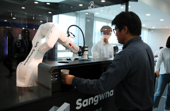 16일 오전 국회 의원회관에서 열린 ‘인간-로봇의 공존시대 로봇이 그리는 미래’ 로봇 전시회에서 한 관람객이 로봇 바리스타가 만든 커피를 받고 있다. 2019.9.16  연합뉴스
