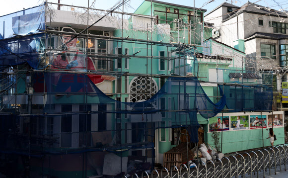 16일 경찰 등에 따르면 이날 오전 마포구 지하철 2호선 홍대입구역 인근에서 개업을 위해 공사 중인 ‘북한식 주점’ 건물 외벽에 부착된 인공기와 김일성 부자 초상화가 철거됐다. 사진은 이날 오후 인공기와 김일성·김정일 부자 초상화가 철거된 ‘북한식 주점’ 건물 모습. 2019.9.16 연합뉴스