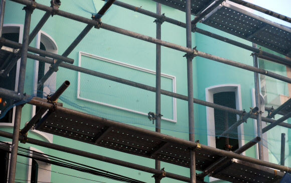 16일 경찰 등에 따르면 이날 오전 마포구 지하철 2호선 홍대입구역 인근에서 개업을 위해 공사 중인 ‘북한식 주점’ 건물 외벽에 부착된 인공기와 김일성 부자 초상화가 철거됐다. 사진은 이날 오후 인공기와 김일성·김정일 부자 초상화가 철거된 ‘북한식 주점’ 건물 모습. 2019.9.16 연합뉴스