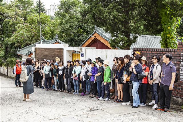 서울미래유산 지정 현판도 없는 박경리 가옥 앞에서 참가자들이 아쉬운 마음으로 해설을 듣고 있다.