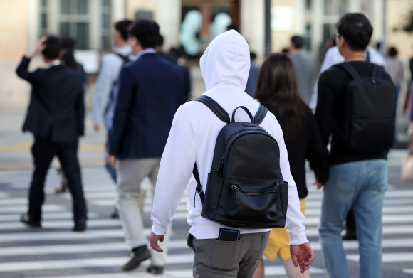 쌀쌀한 날씨를 보인 19일 오전 서울 종로구 세종대로 네거리에서 두꺼운 옷을 입은 시민들이 출근길을 서두르고 있다. 2019.9.19  연합뉴스