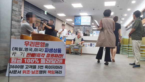 우리은행 독일 국채(10년물) 금리 연계 파생결합펀드(DLF)에 가입했던 투자자들이 19일 경기도 성남시 우리은행 위례신도시지점을 방문해 항의 시위를 하고 있다.  2019.9.19   이종원 선임기자 jongwon@seoul.co.kr
