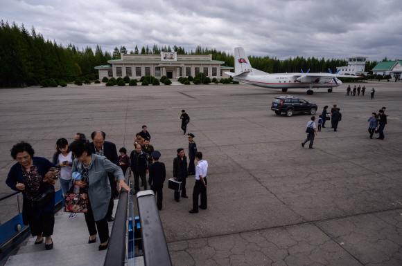 A photo taken on September 13, 2019 shows passengers boarding a Tupolev TU-134 aircraft before departing for Pyongyang, North Korea‘s northern city of Samjiyon. - The monumental construction project in the far reaches of North Korea ordered by leader Kim Jong Un, involves nothing less than the rebuilding of the entire town of Samjiyon, the seat of a county which includes the supposed birthplace of Kim’s father and predecessor Kim Jong Il, and Mount Paektu, the spiritual birthplace of the Korean nation. The plan includes a museum of revolutionary activities, a winter sports training complex, processing plants for blueberries and potatoes -- two of the area‘s most important crops -- a new railway line to Hyesan, and 10,000 apartments. (Photo by Ed JONES / AFP) / To go with NKorea-politics-economy-construction-Samjiyon, FOCUS by Sebastien Berger/2019-09-20 11:08:15/ <저작권자 ⓒ 1980-2019 ㈜연합뉴스. 무단 전재 재배포 금지.>
