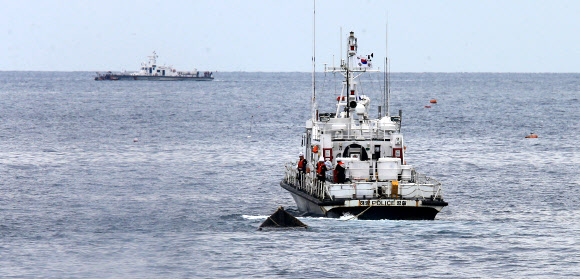 20일 오전 9시께 강원 고성군 죽왕면 문암항 동방 약 2㎞ 해상에서 북한 어선으로 추정되는 목선이 해경경비정에 의해 모처로 예인되고 있다. 2019.9.20  연합뉴스