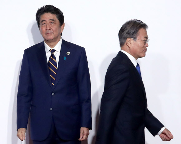 지난 6월 일본 오사카에서 열린 G20 정상회의 공식환영식에서 문재인(오른쪽) 대통령이 의장국인 일본 아베 신조 총리와 악수한 뒤 이동하고 있다. 두 정상의 다소 어색한 표정은 양국의 차가운 관계를 그대로 보여주는 듯 하다. 서울신문 DB 