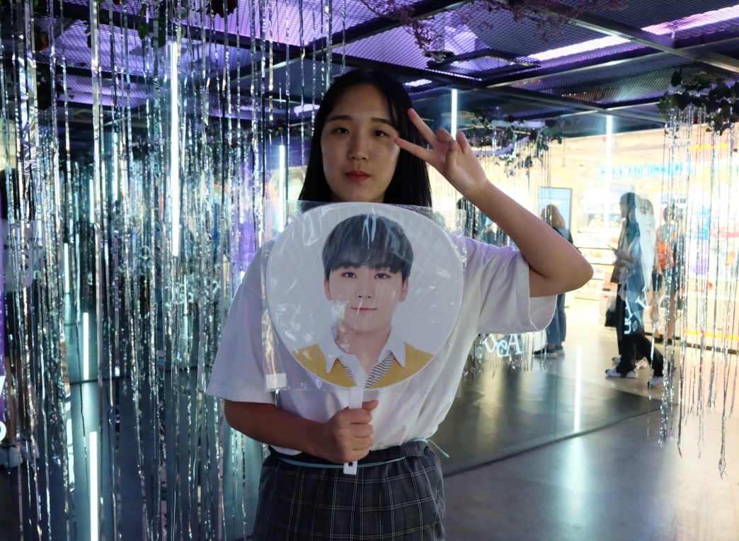 세븐틴의 ‘데뷔 팬’ 정예슬양이 최애 승관의 사진이 인쇄된 부채를 들고 포즈를 취하고 있다.