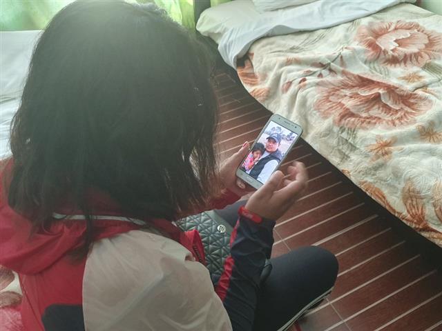 　Lili Maya Gurung looks at a photo of her husband and daughter together. Her husband Bal Bahadur Gurung died after jumping off the Wolleung Bridge in Jungnang District, Seoul, June 2018. Bal B. Gurung who had first come to South Korea with work permit feared deportation after becoming unregistered as he failed to secure employment.